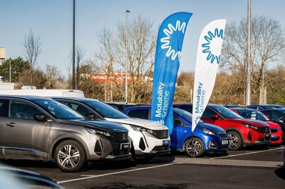 Cars parked in front of a Motability sign
