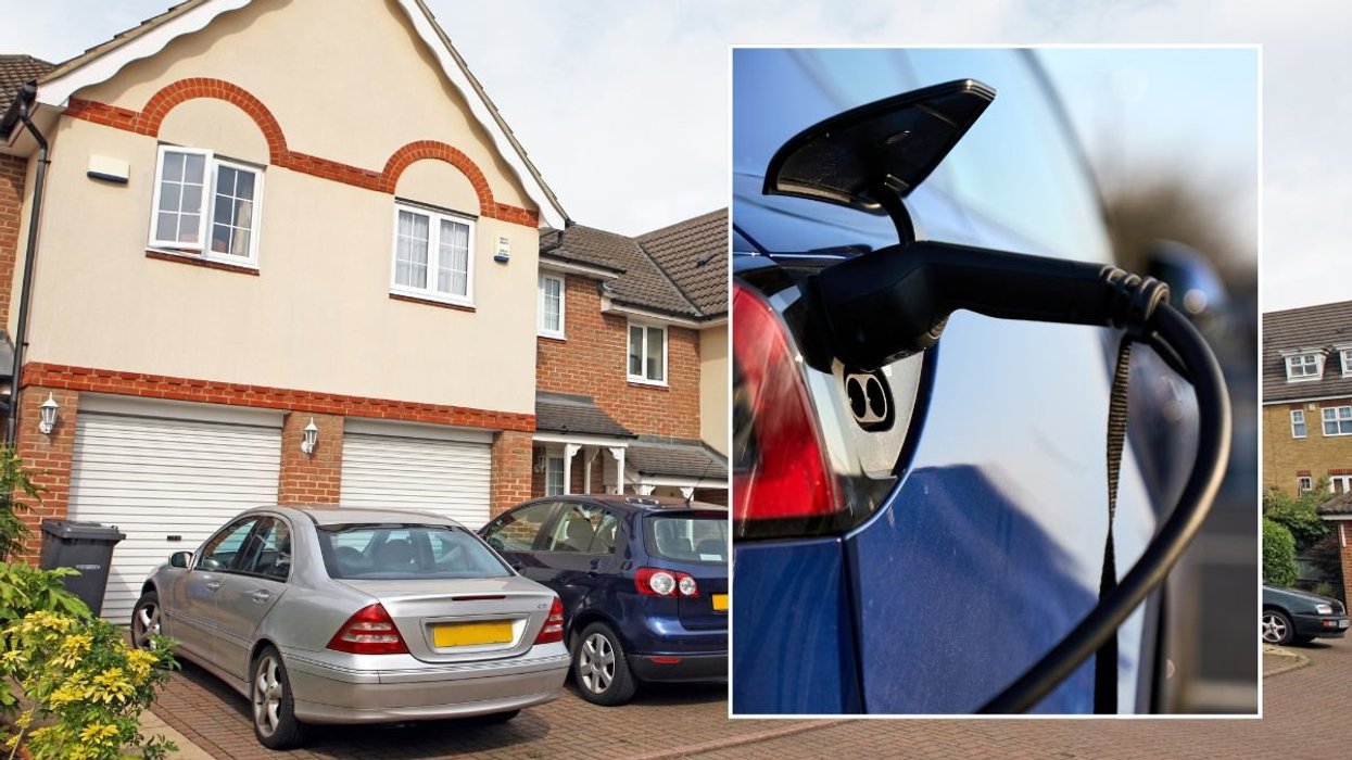 Cars parked outside of a house and an electric car charging