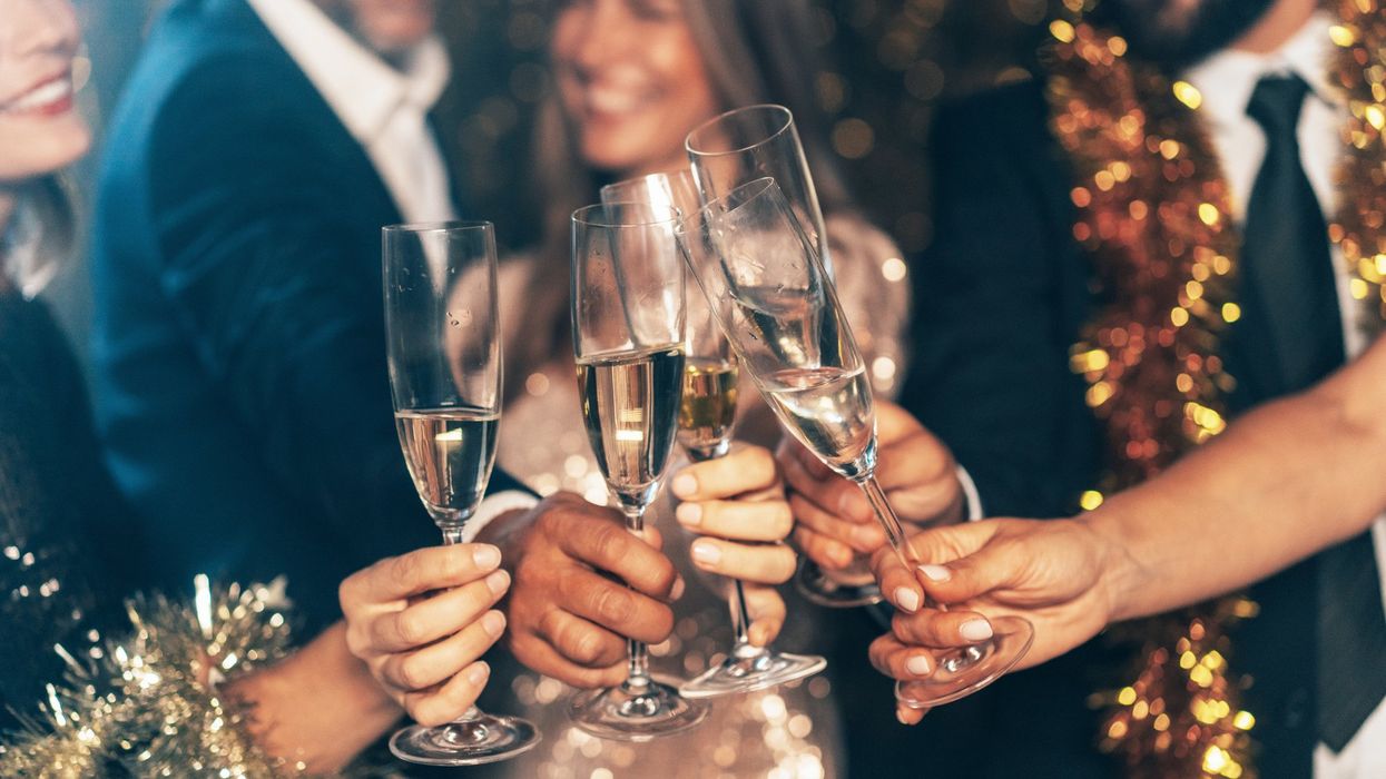 Champagne glasses held up together by people celebrating