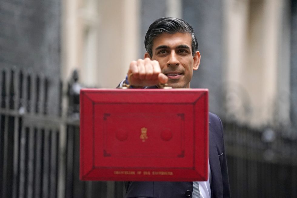Chancellor of the Exchequer Rishi Sunak holds his ministerial 'Red Box' as he stands with his ministerial team and Parliamentary Private Secretaries, outside 11 Downing Street, London, before delivering his Budget to the House of Commons.