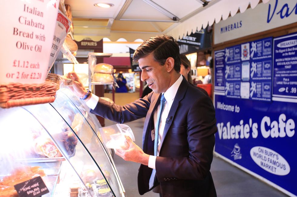 Chancellor of the Exchequer Rishi Sunak visits a stand at the Bury Market in Lancashire, the day after presenting his budget to the House of Commons.