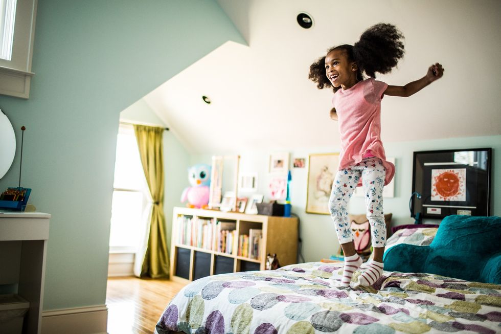 Child jumping on her bed