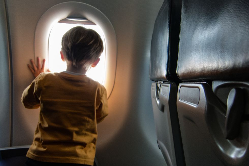 Child looking out of window on plane