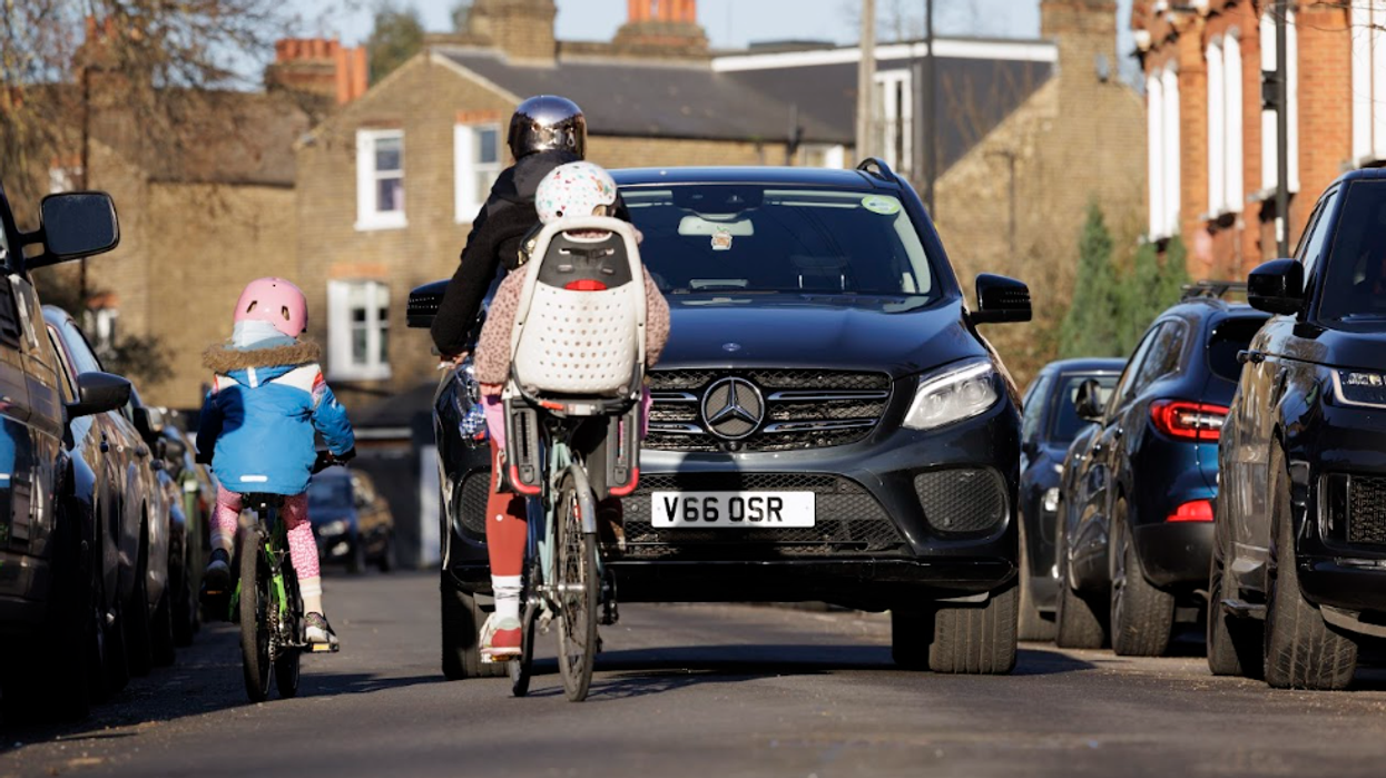 Children on bikes near SUV driving on roads