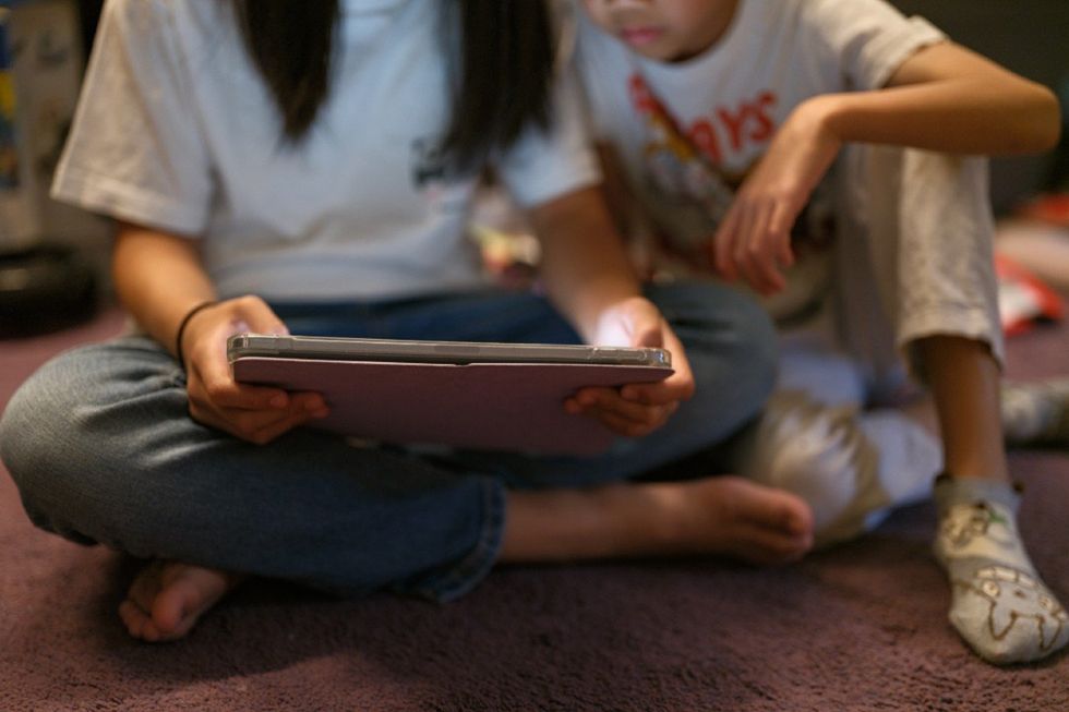 Children using a tablet to access social media