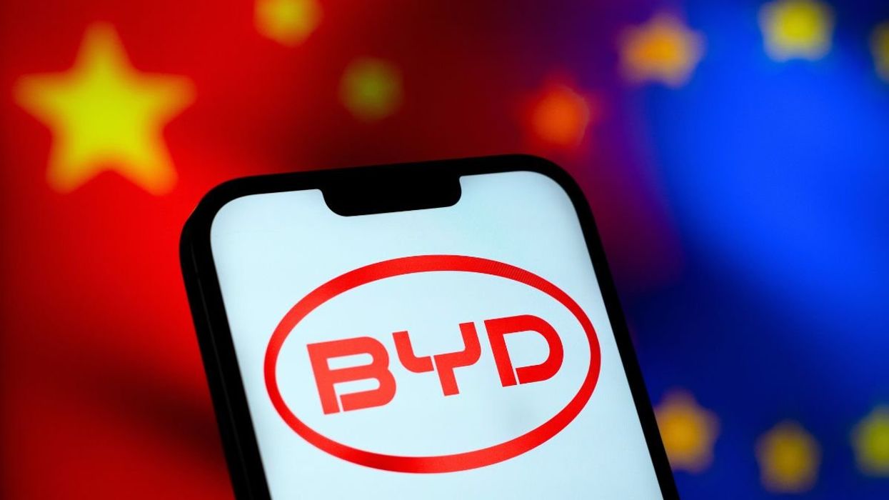 Chinese and EU flag in the background, with a BYD logo in front