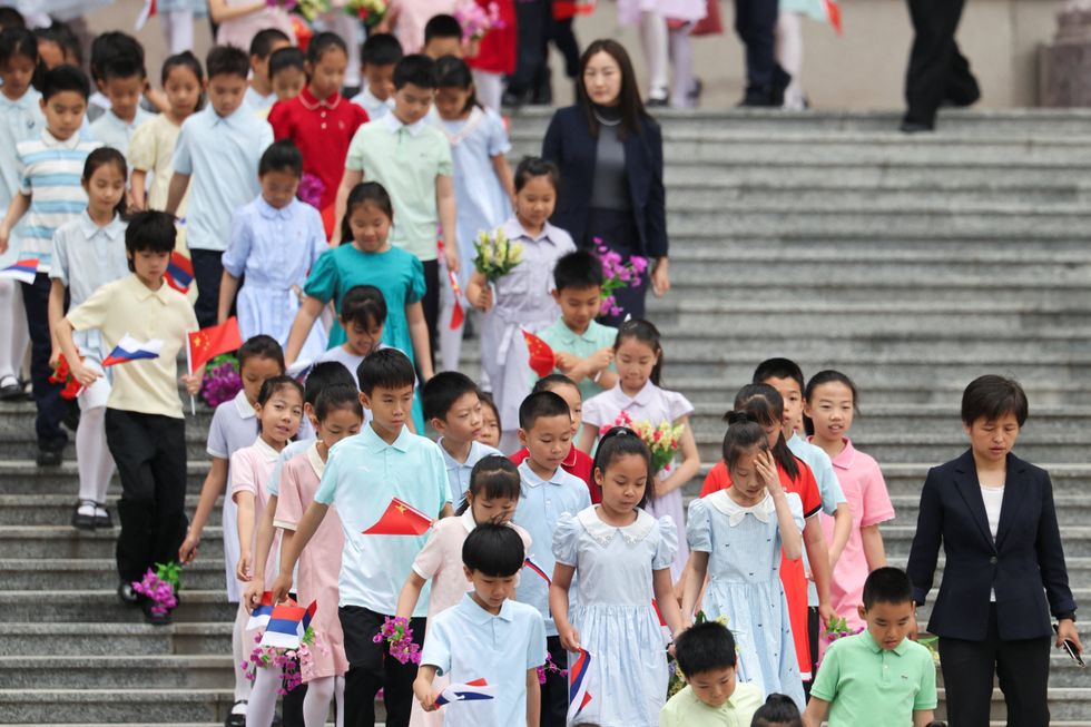 Chinese children holding Russian and Chinese flags ahead of Putin state visit