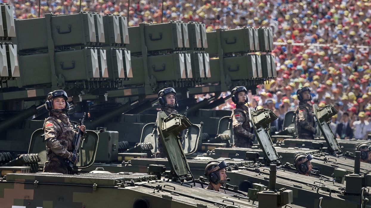 Chinese soldiers ride on armoured missile carriers as they pass in front of Tiananmen Square and the Forbidden City during a military parade on September 3, 2015