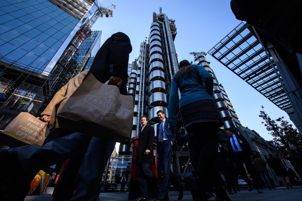 City workers walk past the Lloyds building in the financial district, also known as the Square Mile, on January 20, 2017