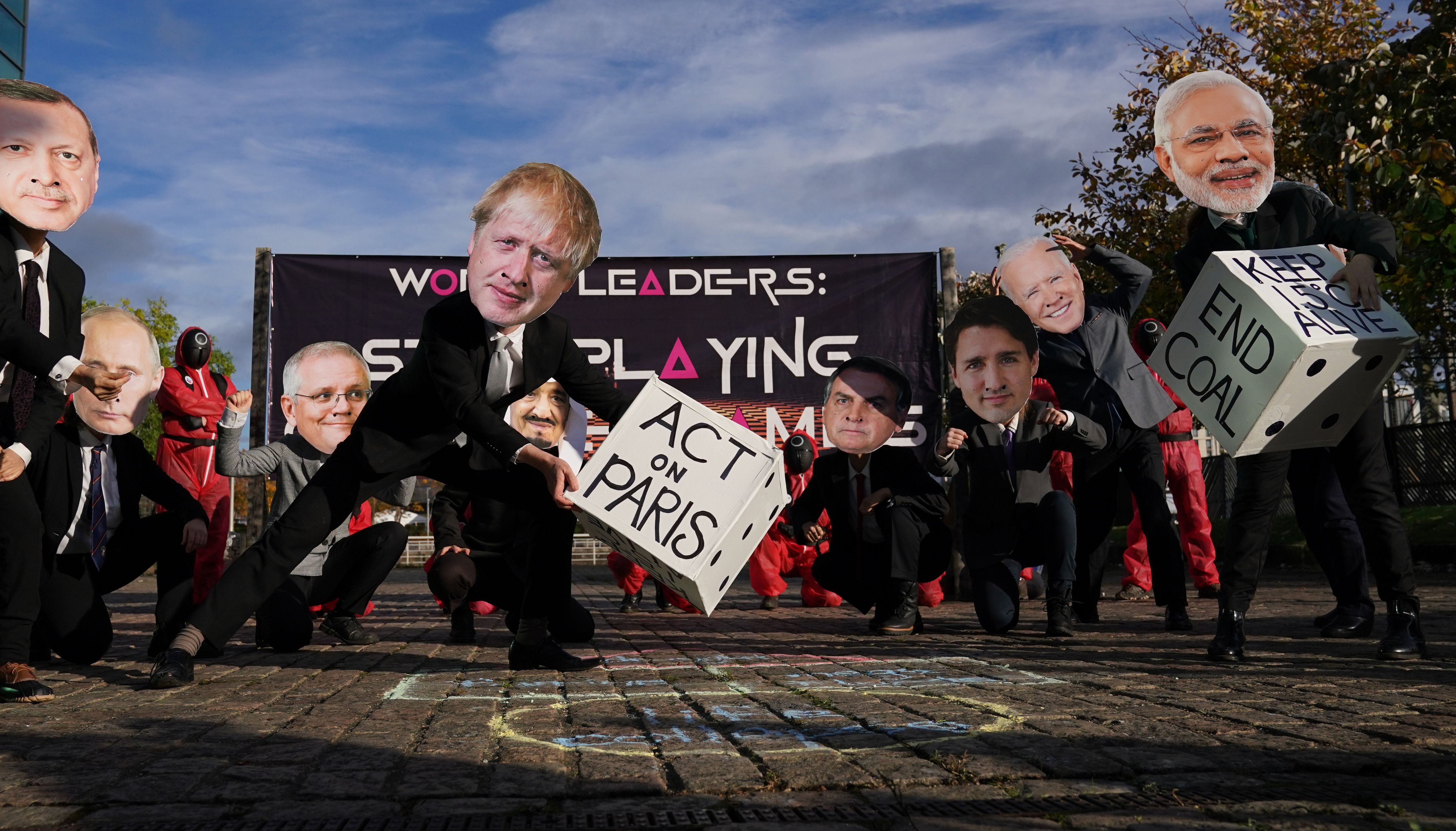Climate activists from the Glasgow Actions Team, wear Squid Game costumes and world leader masks, play tug of war and climate hopscotch during a protest at the Clyde Arc Bridge during the Cop26 summit at the Scottish Event Campus (SEC) in Glasgow.
