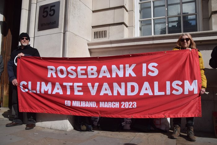 Climate activists hold a banner with the quote 'Rosebank is Climate Vandalism, Ed Miliband, March 2023'
