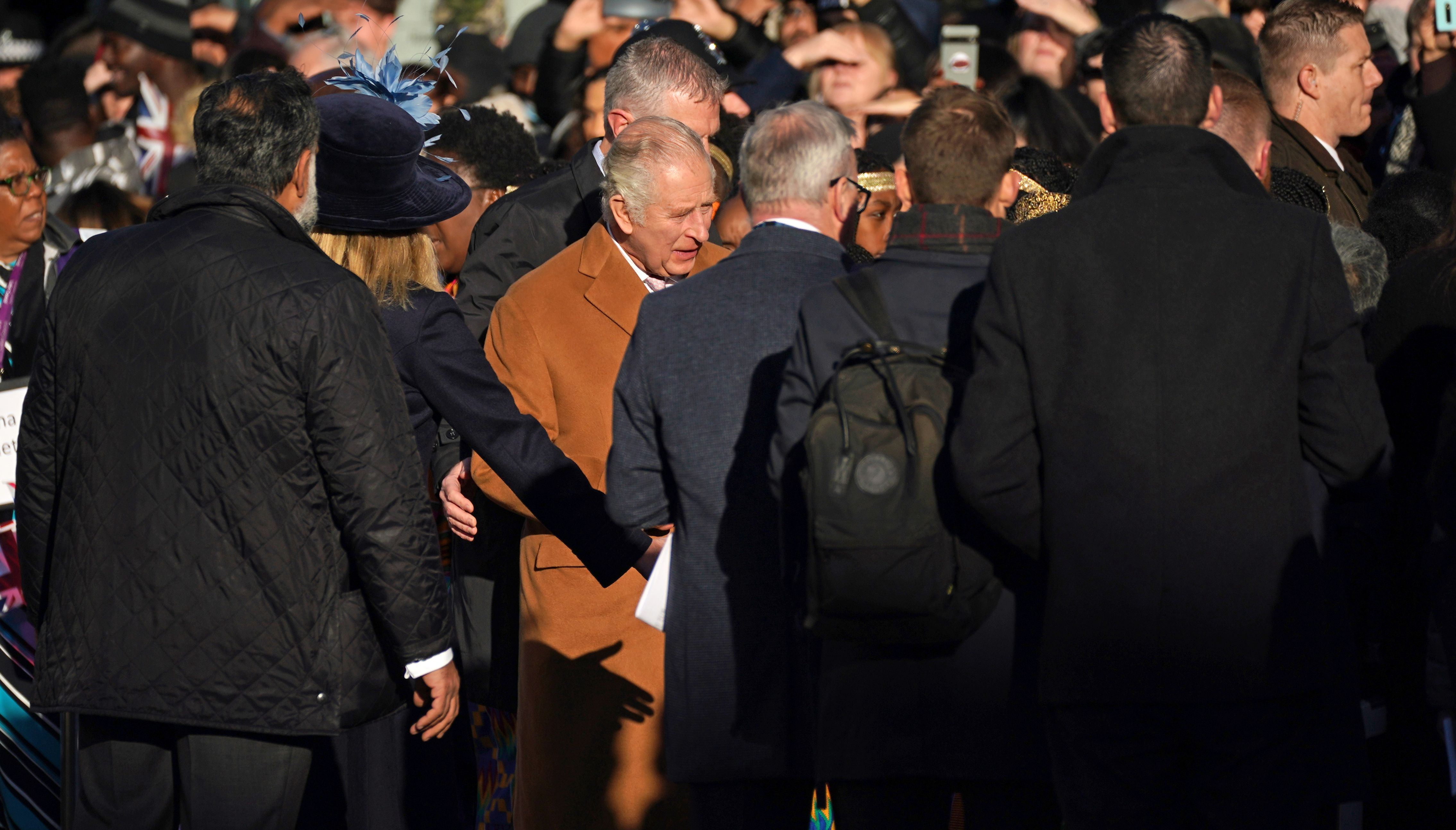 Close-protection officers usher King Charles III out of the way as he was meeting members of the public during a visit to Luton.