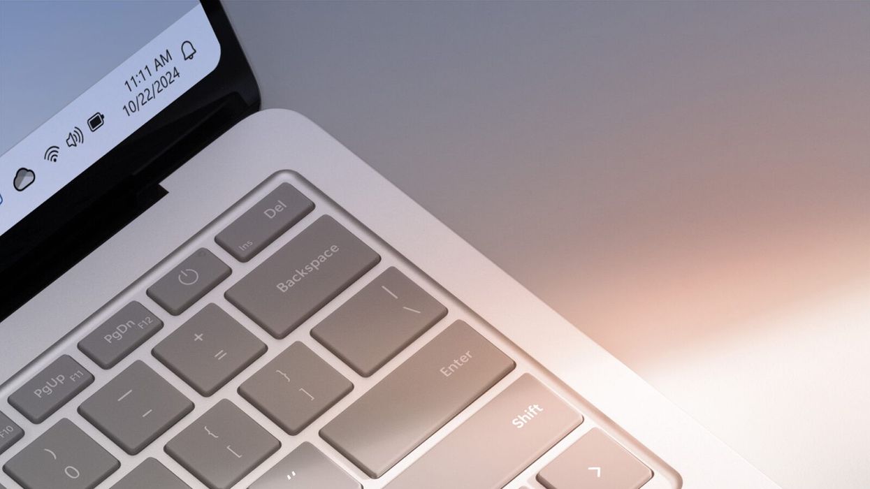 close-up shot of a windows 11 laptop keyboard with a hint of the operating system shown in the corner of the screen