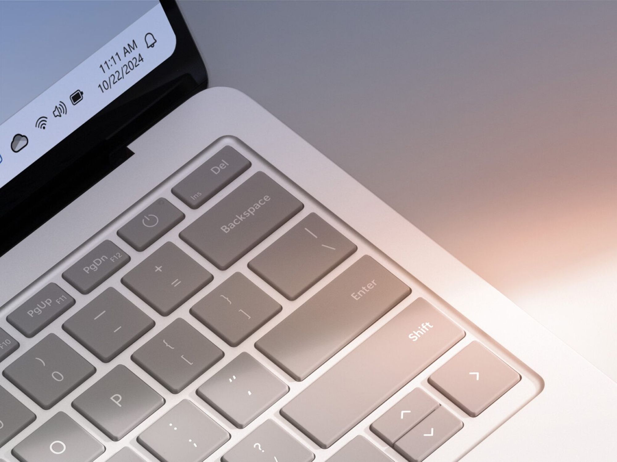 close-up shot of a windows 11 laptop keyboard with a hint of the operating system shown in the corner of the screen