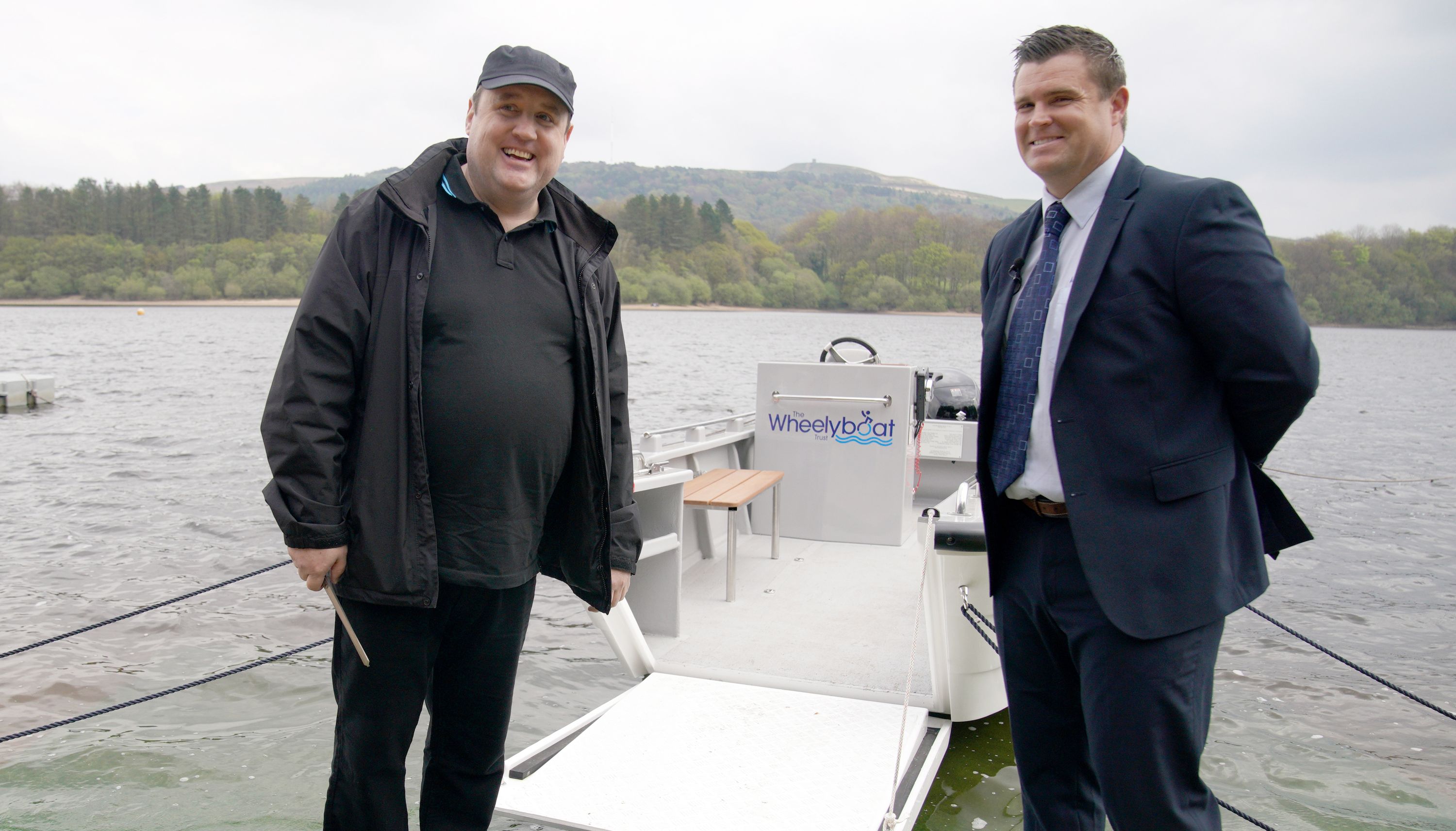Comedian Peter Kay (left), stands with David Germain, CEO of the Anderton Centre, as he officially launches the Coulam Wheelyboat V17, a purpose-built fully wheelchair accessible powerboat at the Anderton Centre located on the banks of the Lower Rivington Reservoir near Bolton in Lancashire. Picture date: Saturday April 23, 2022.