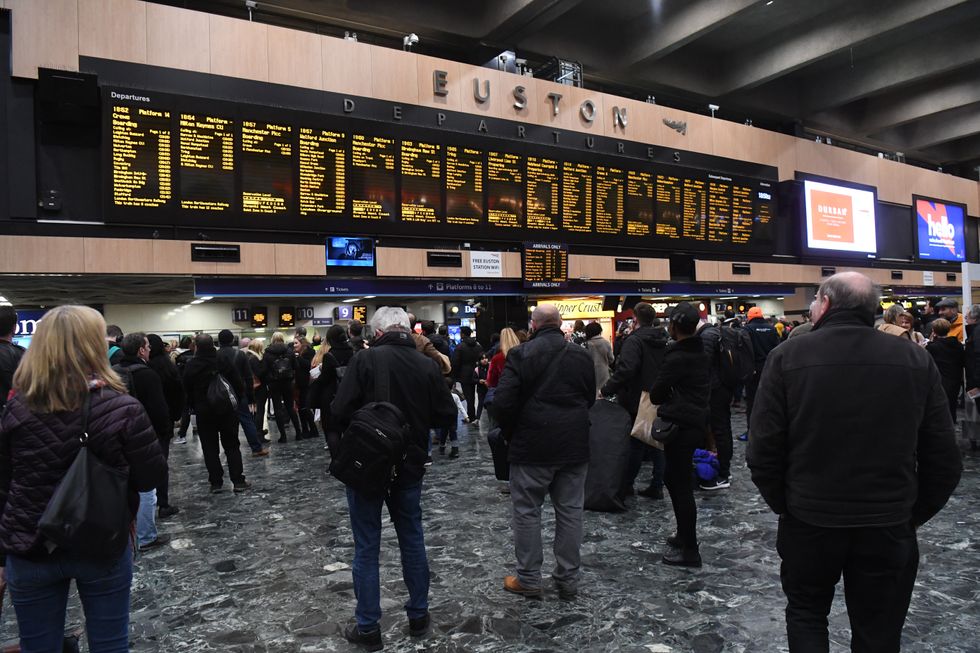 Commuters wait for trains at Euston Station in London