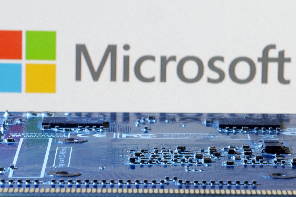 computer chip pictured with microsoft logo in the background 