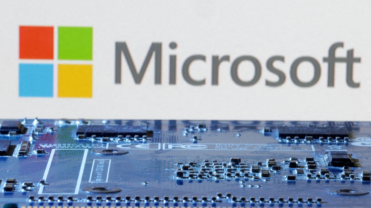 computer chip pictured with microsoft logo in the background