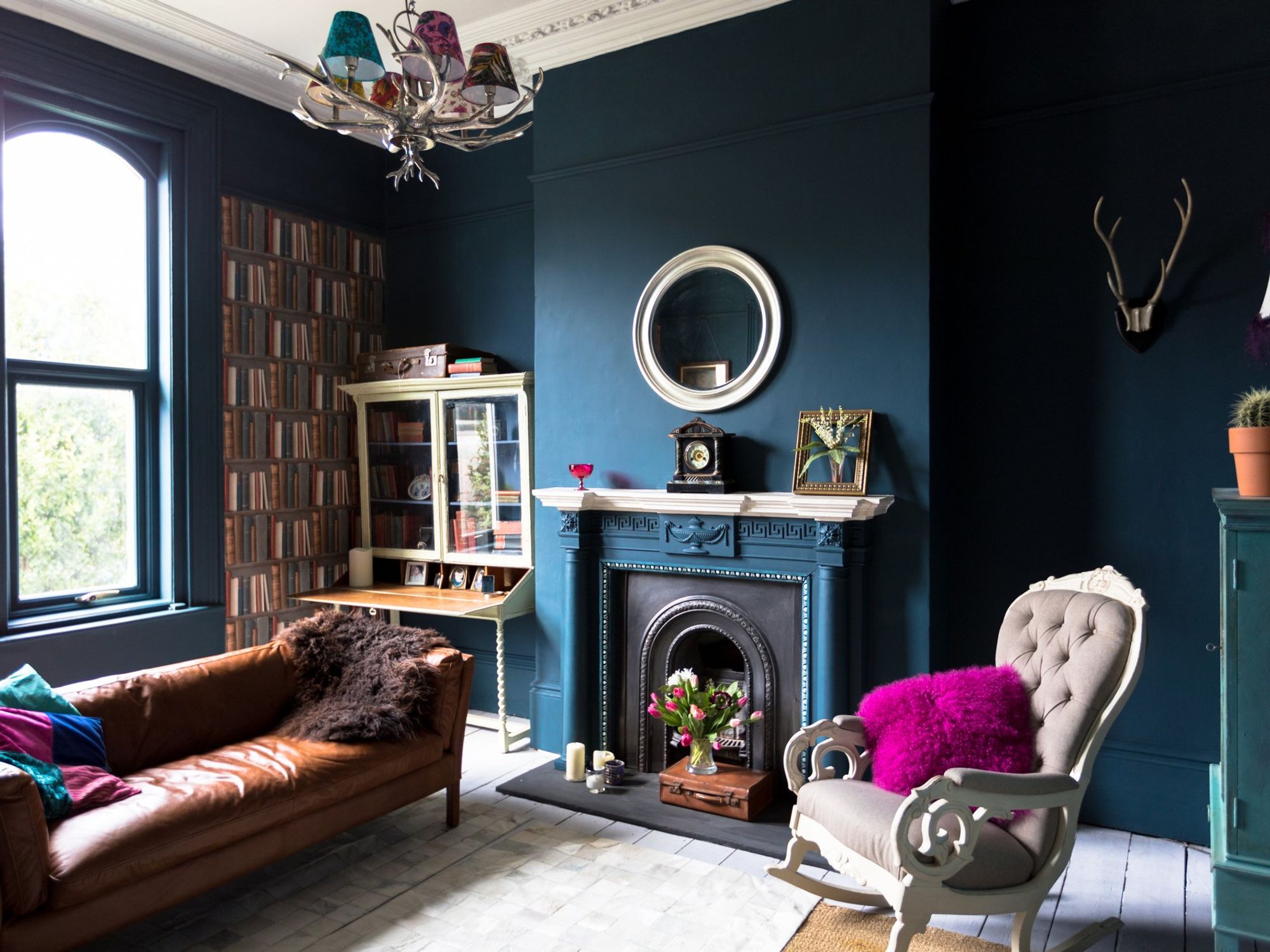 Cosy living room with rich colours, blue walls and purple cushions