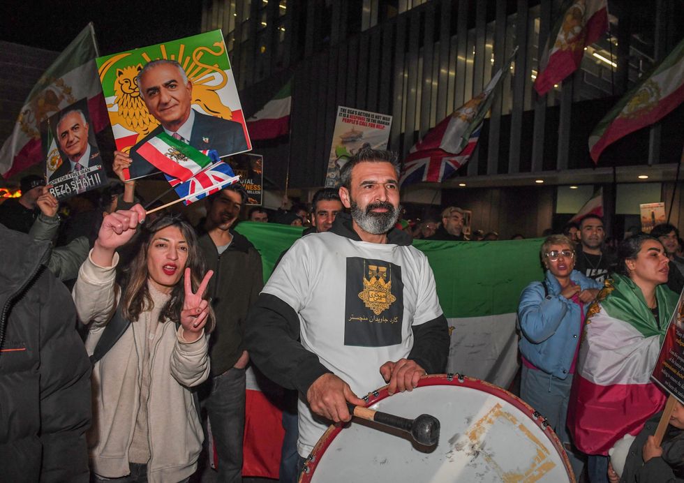 Contra-manifestantes tocavam tambores e seguravam uma foto de Reza Pahlavi