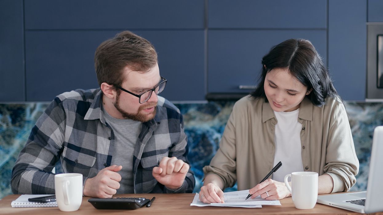 Couple at kitchen table sorting finances