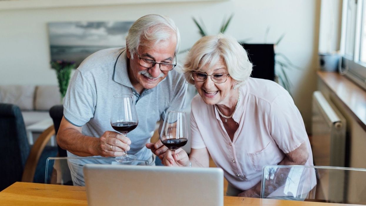Couple at laptop celebrating with wine