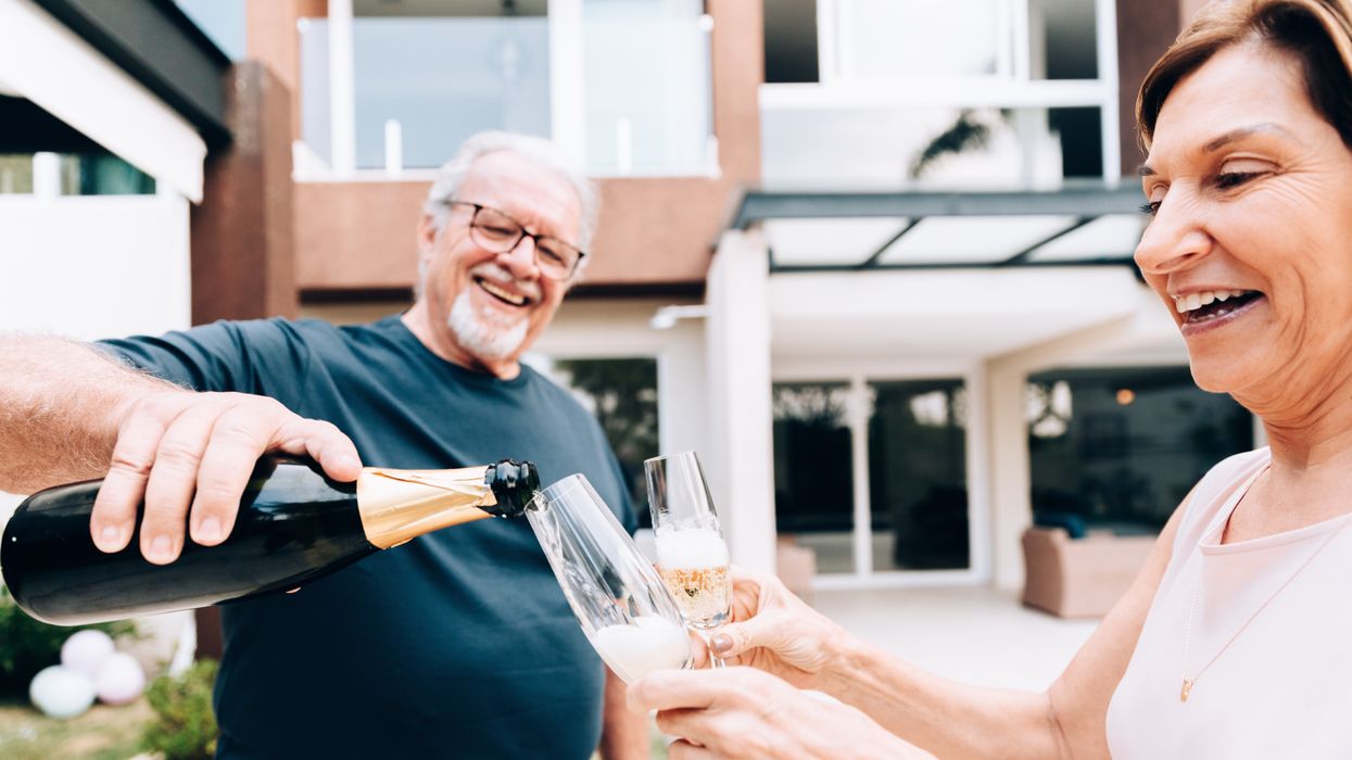 Couple celebrate with a bottle of fizz