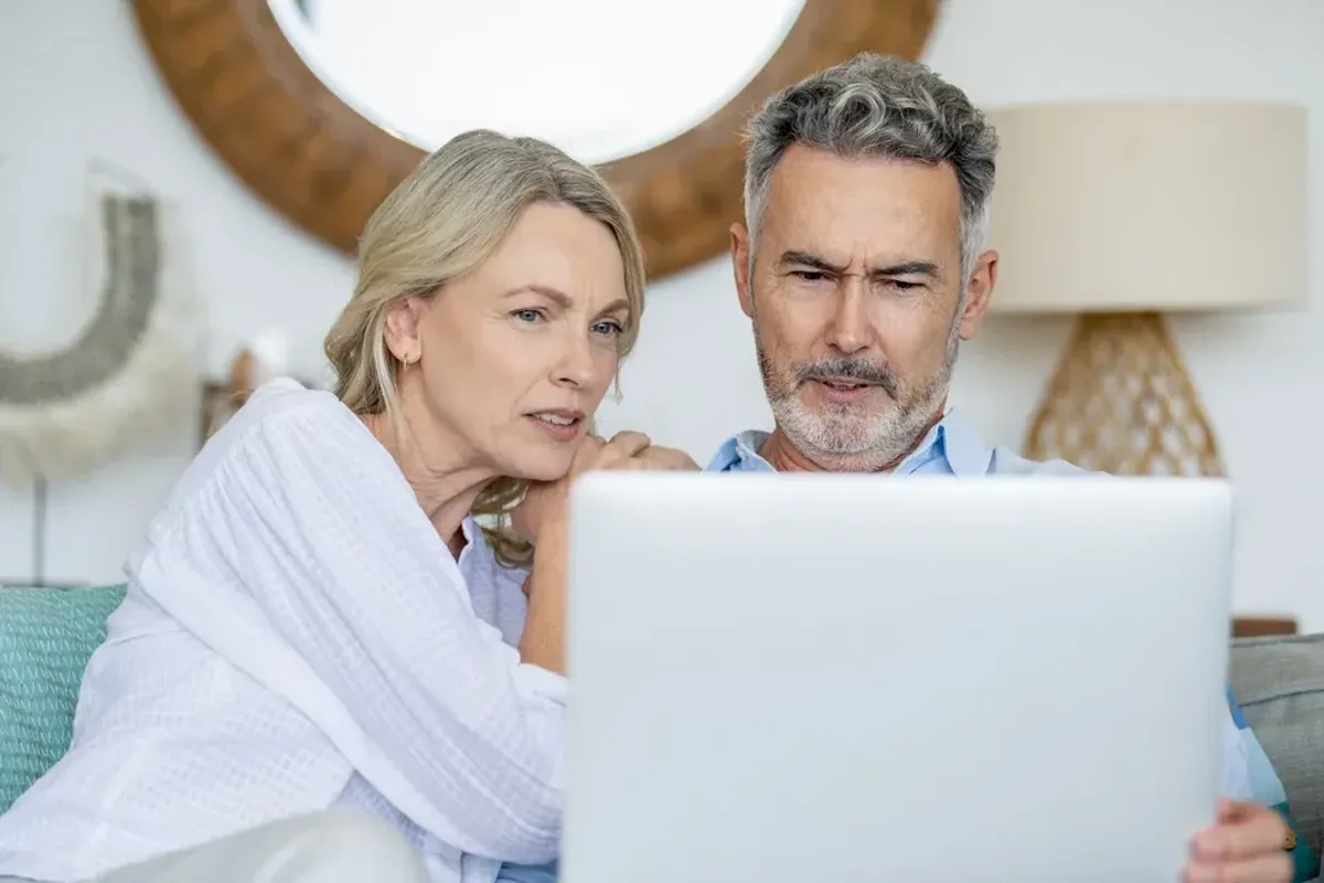 Couple confused looking at laptop