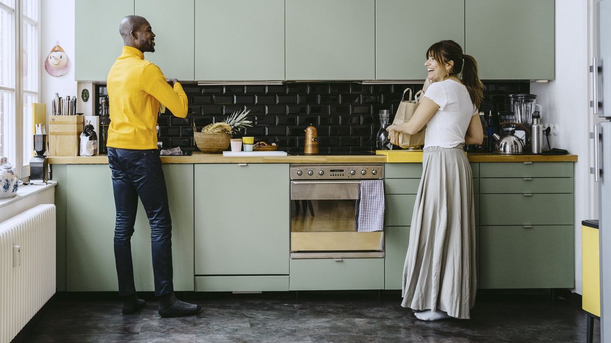 Couple in kitchen, light green cabinets