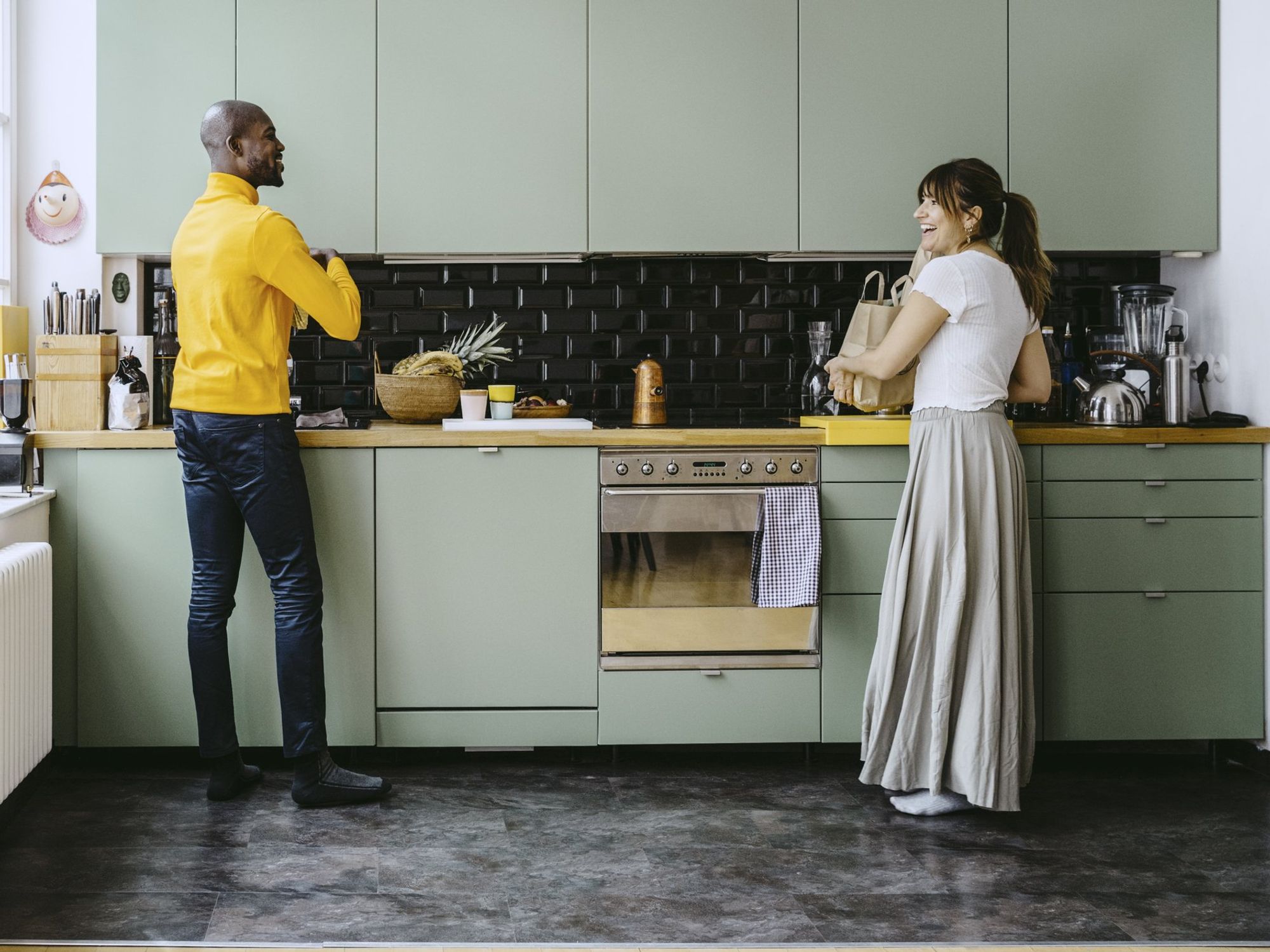 Couple in kitchen, light green cabinets