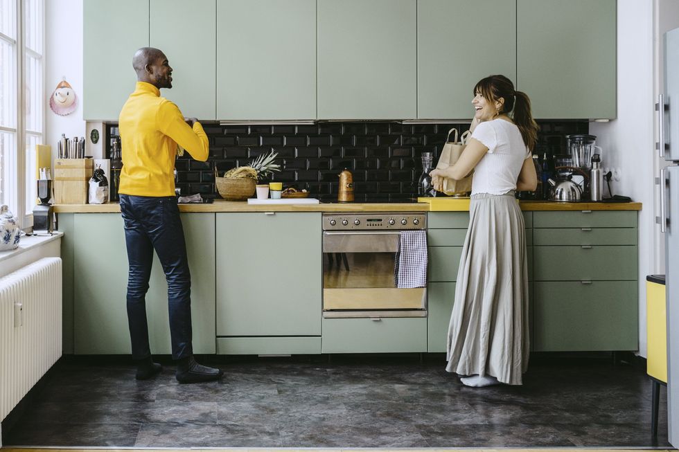 Couple in kitchen, light green cabinets