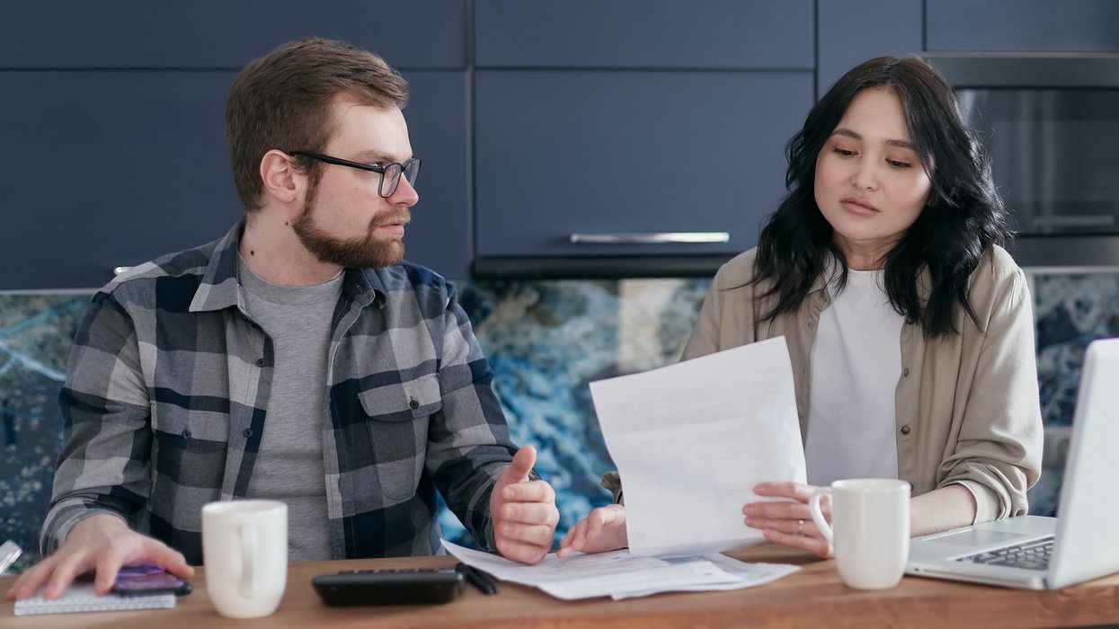 Couple look at finances in kitchen