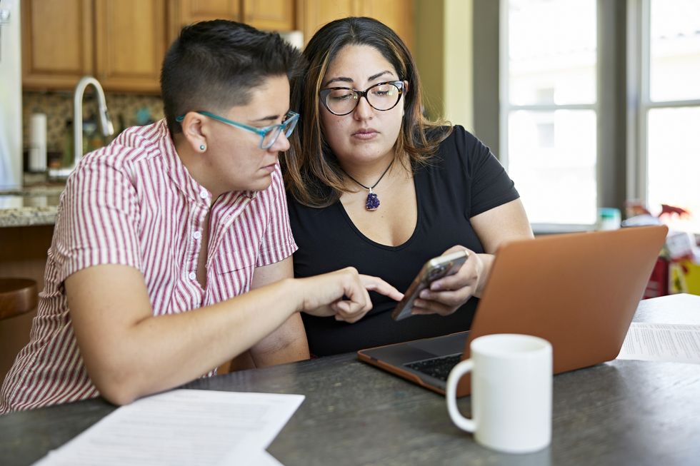 Couple look at finances on laptop and phone