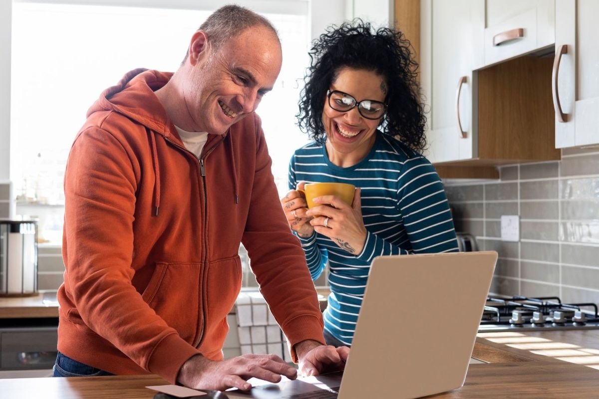 Couple look happy at laptop