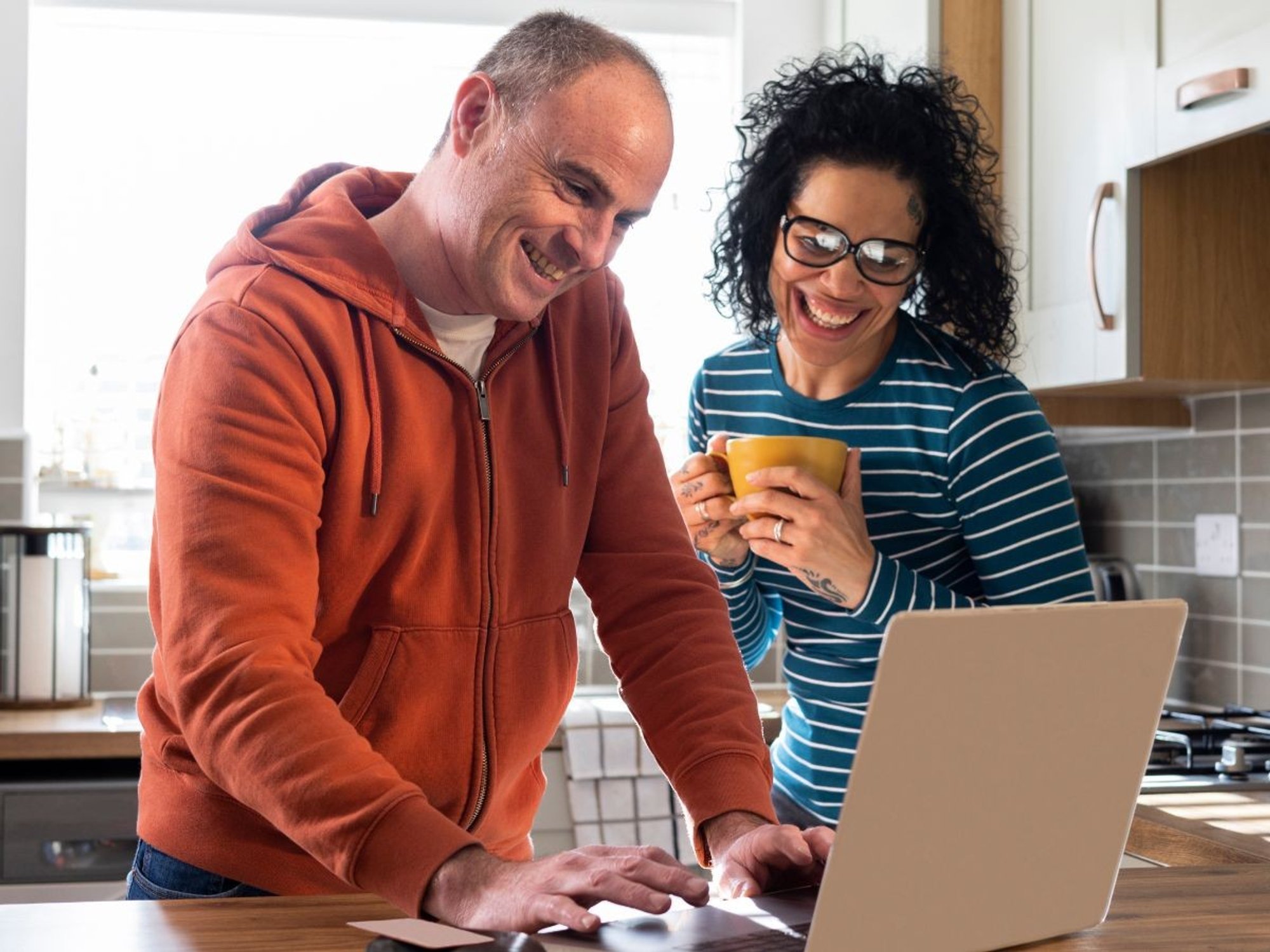 Couple look happy at laptop