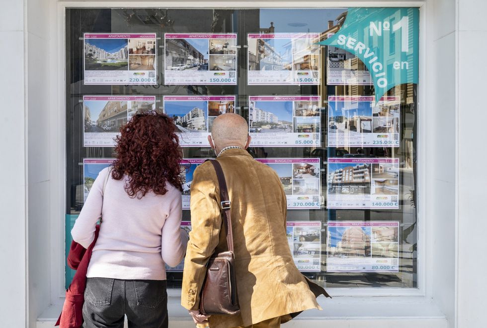 Couple look through an estate agent's window