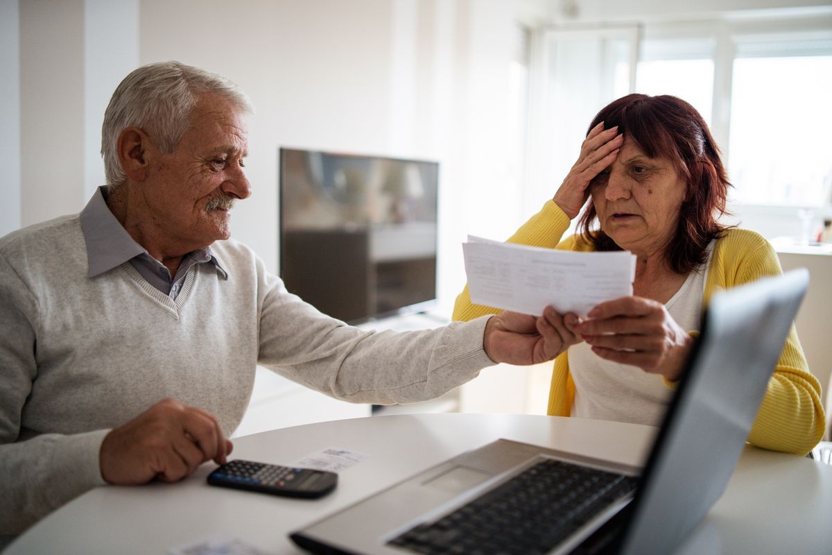 Couple look worried at documents 