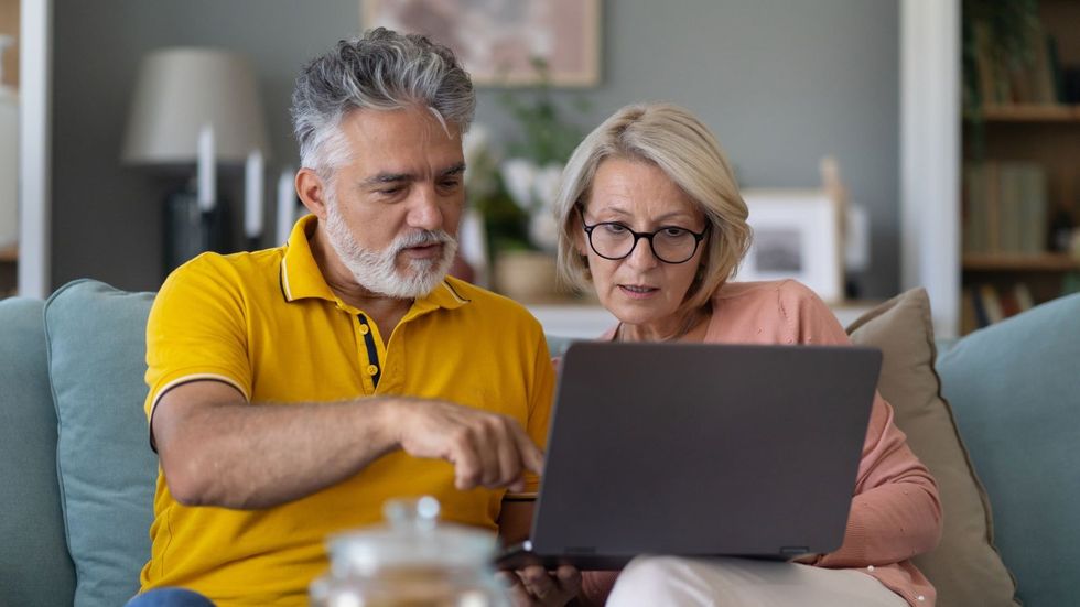 Couple look worried at laptop