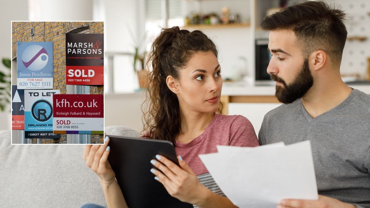 Couple looking at tab with house for sale signs