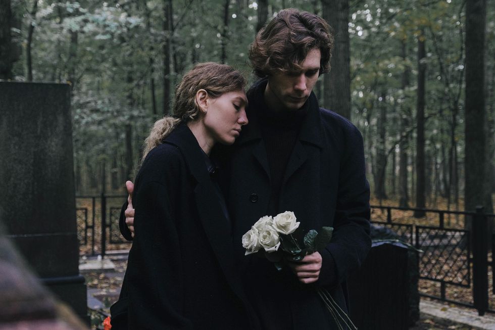 Couple mourning at graveyard