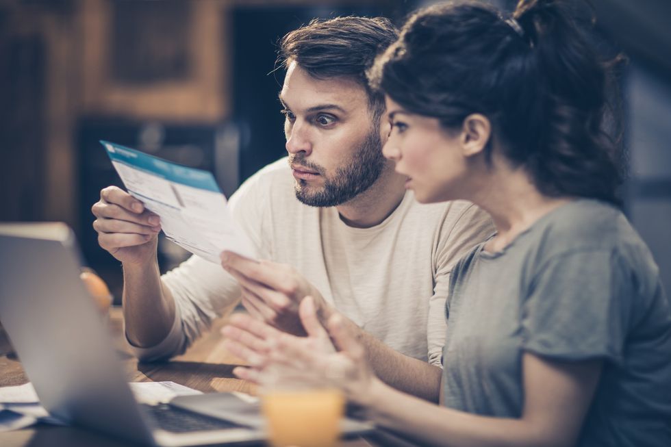 Couple shocked looking at bill