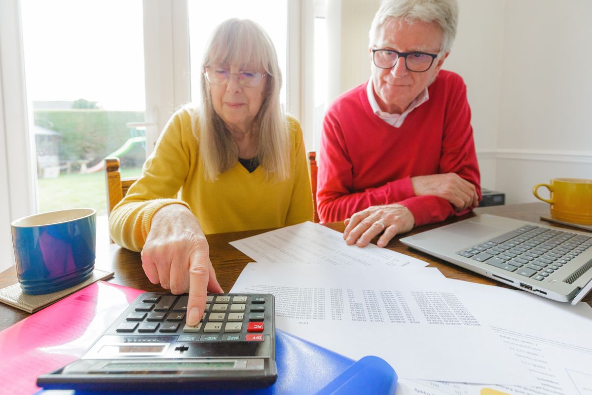 Couple use calculator while they look at finances
