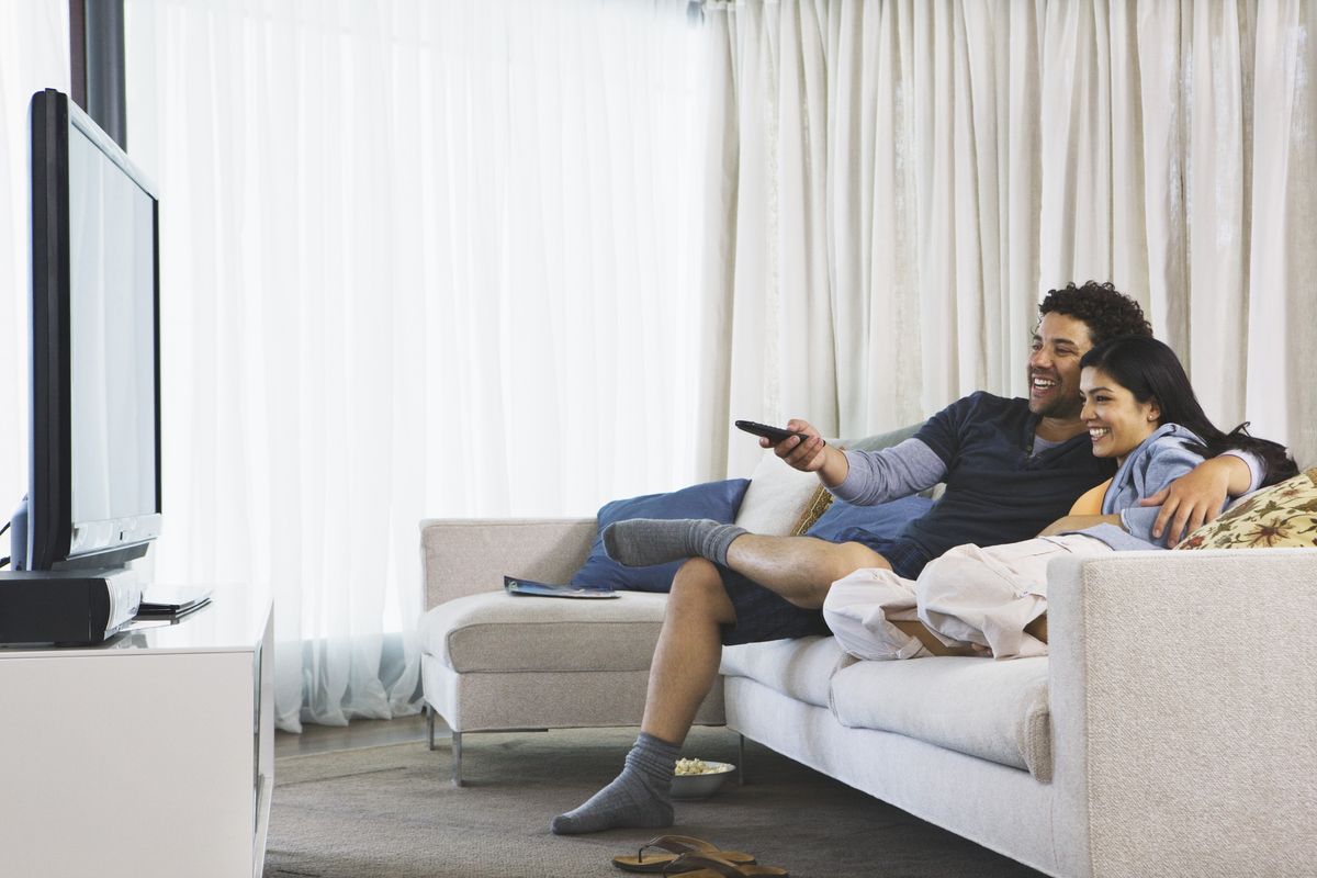 Couple watches TV on sofa