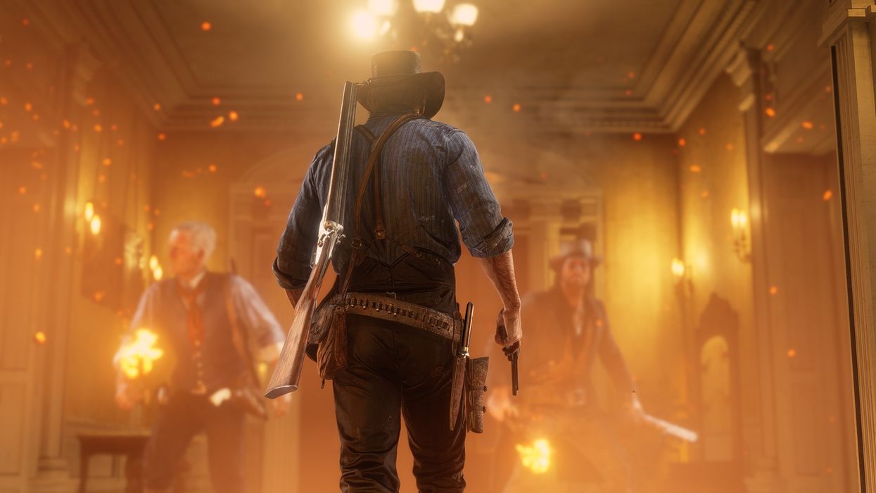 cowboy with his back to the camera holding pistols with a room on fire infront of him
