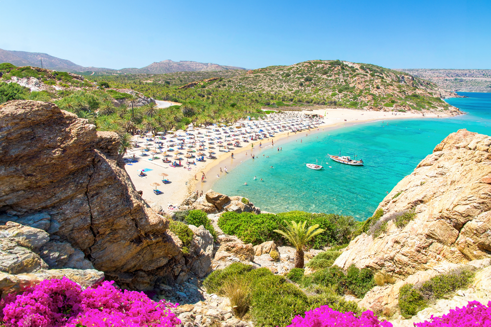 Crete shore with blue waters and pink blossoms