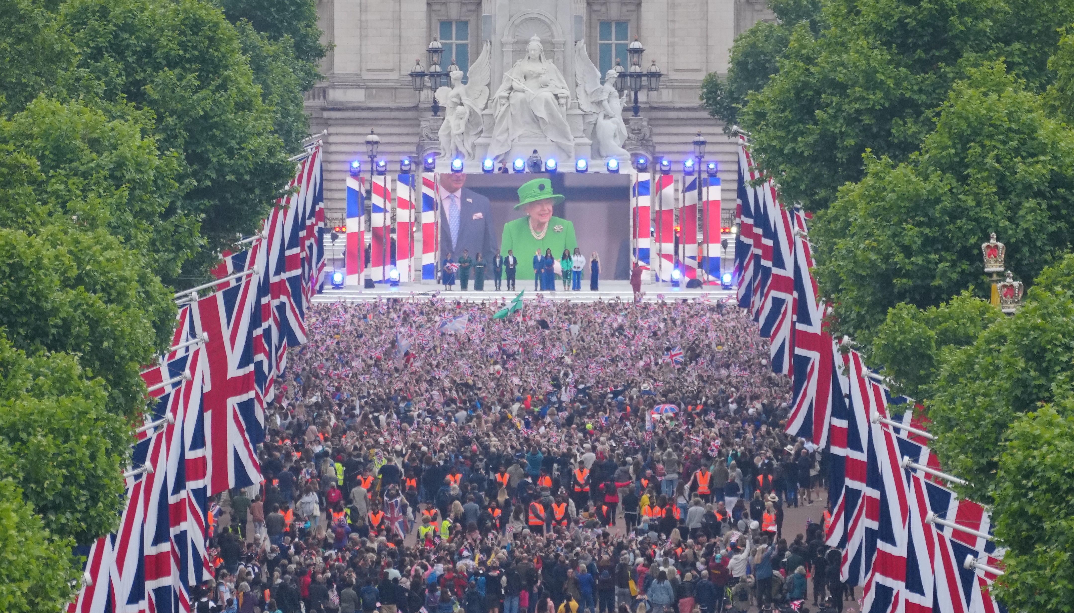 Crowds are seen on The Mall with Queen Elizabeth II shown on a screen during the singing of the National Anthem at the Platinum Jubilee Pageant in front of Buckingham Palace, London, on day four of the Platinum Jubilee celebrations. Picture date: Sunday June 5, 2022.
