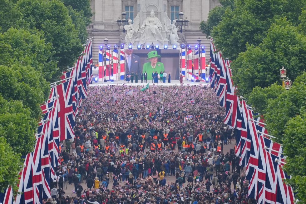 Crowds are seen on The Mall with Queen Elizabeth II shown on a screen during the singing of the National Anthem at the Platinum Jubilee Pageant in front of Buckingham Palace, London