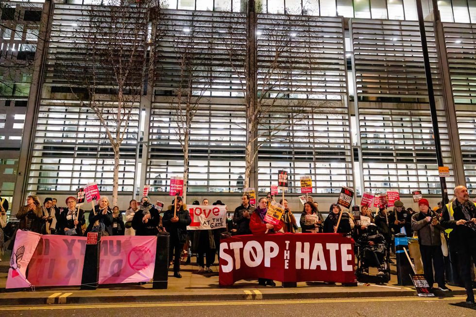 Crowds of protesters hold placards and banners to support refugees in the UK during the protest outside the Home Office in London