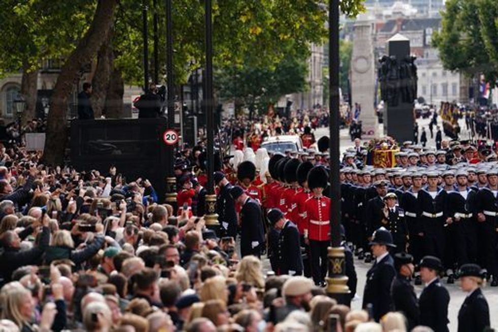 Crowds watch as the State Gun Carriage carries the coffin of Queen Elizabeth II in the Ceremonial Procession following her State Funeral at Westminster Abbey, London. Picture date: Monday September 19, 2022.
