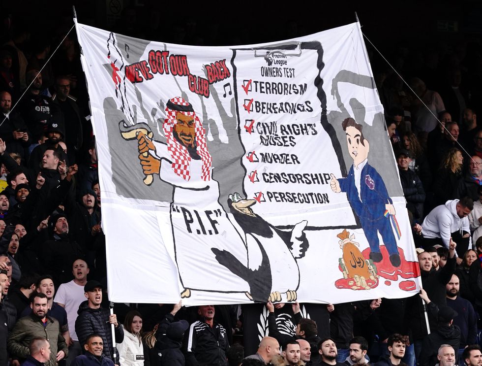 Crystal Palace fans in the stands hold up a banner criticising the new ownership of Newcastle United during the Premier League match at Selhurst Park.